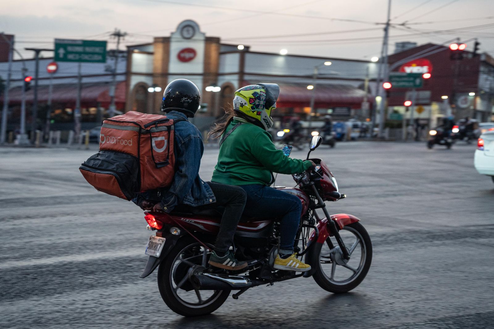 Repartidor en motocicleta urbana con caja DiDi Food